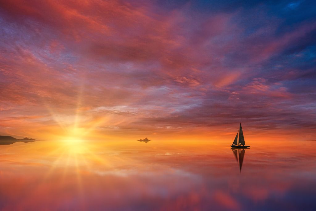 a lonely boat on the sea at sunset