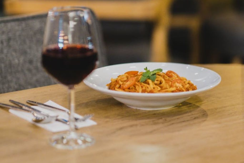 spaghetti bolognese and a glass of red wine on  a table