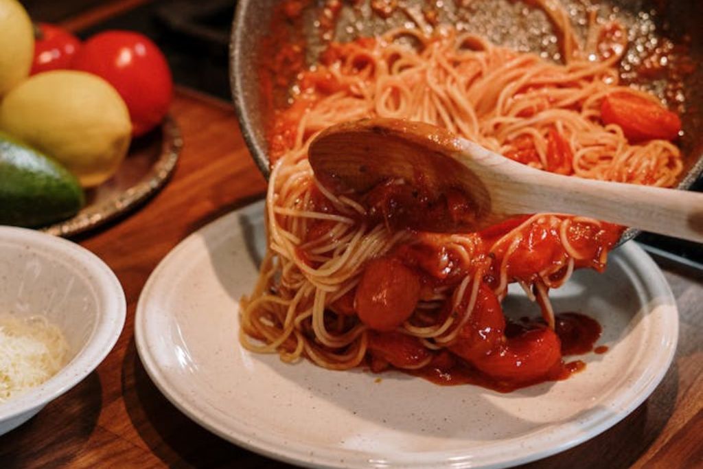 moving spaghetti bolognese from the pan to the plate