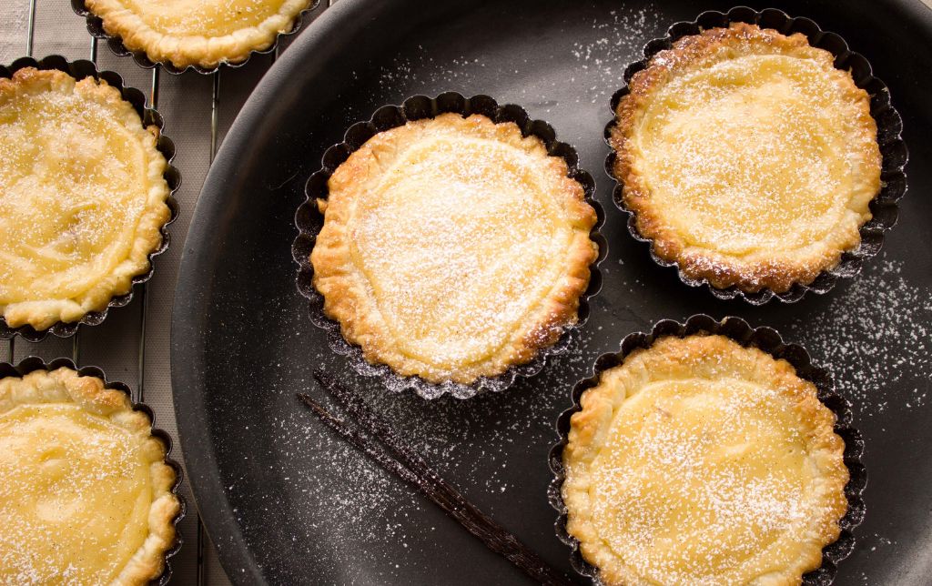 small mango peach hand pies on a dark tray and cooling rack