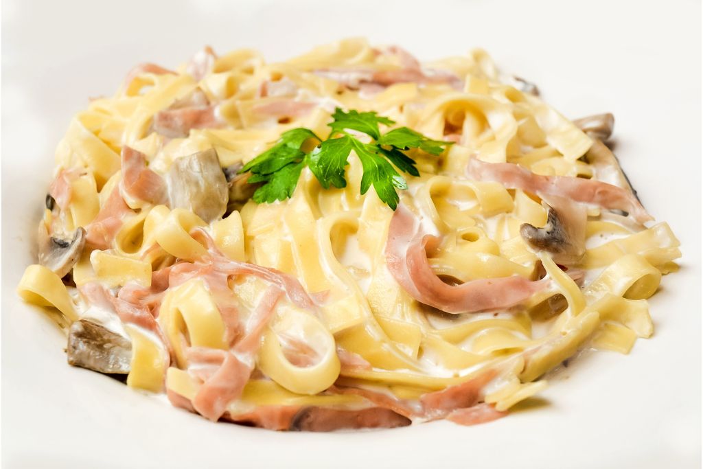 spaghetti Alfredo variation with ham and mushrooms on a plate