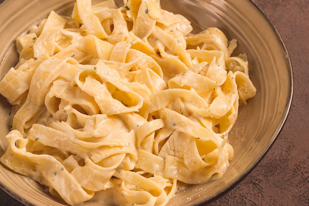 Alfredo fettuccine on a brown plate
