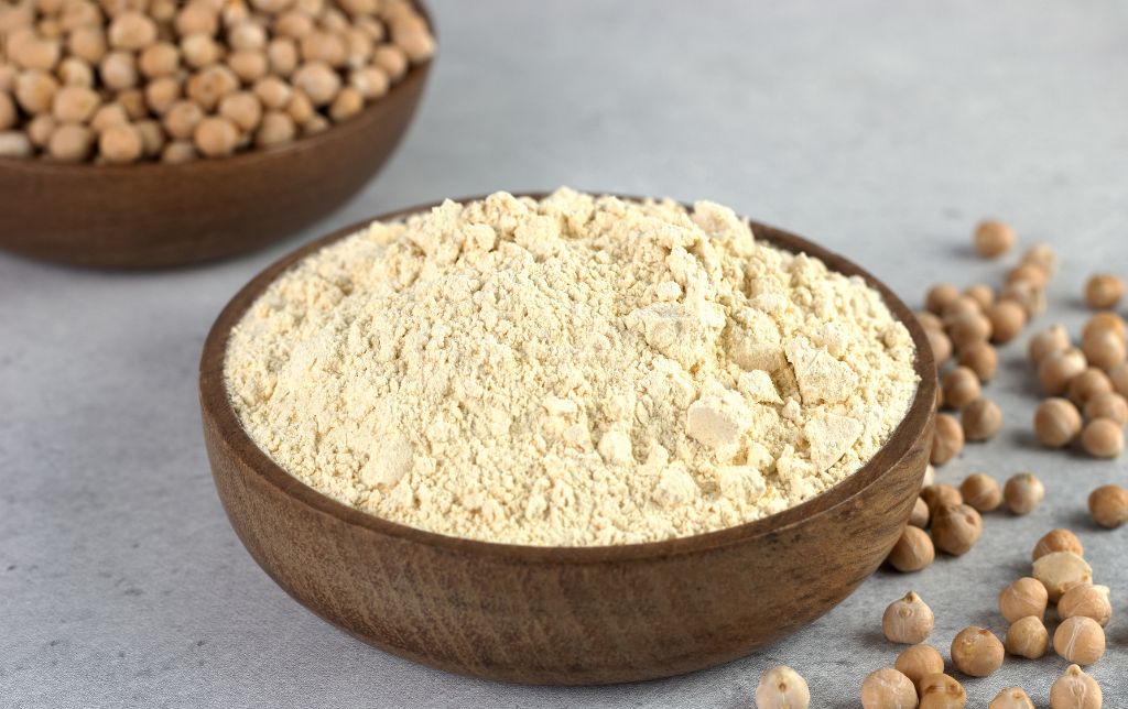 a bowl of entire hazel nuts and a bowl of hazelnut flour sitting next to each other on a table with hazel nuts