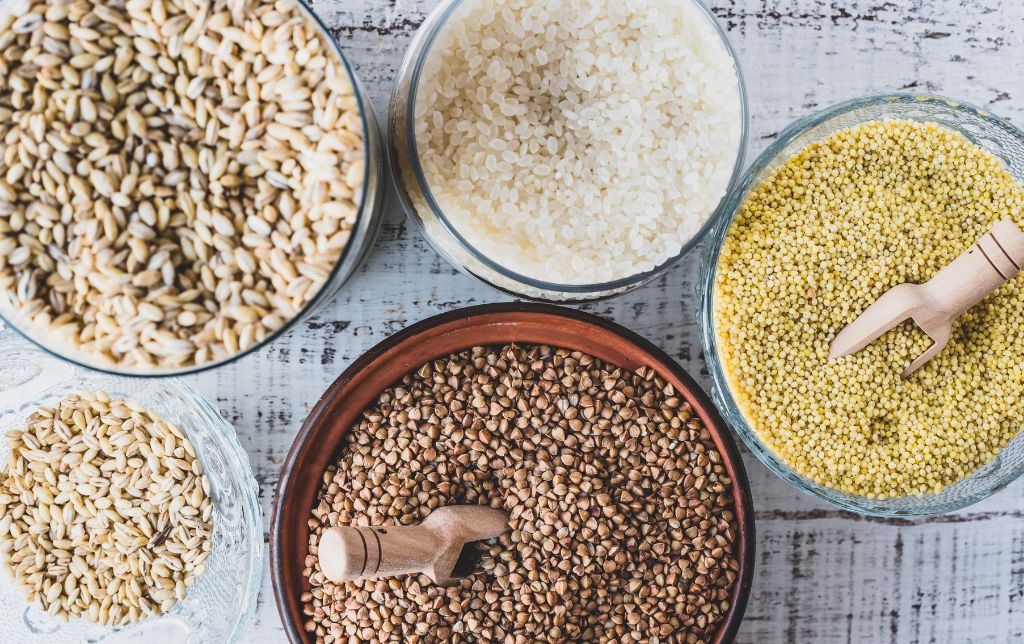 5 bowls of gluten free cereals on a wooden table