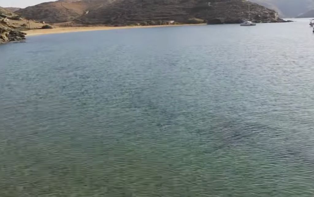 clear water with a small beach in the back