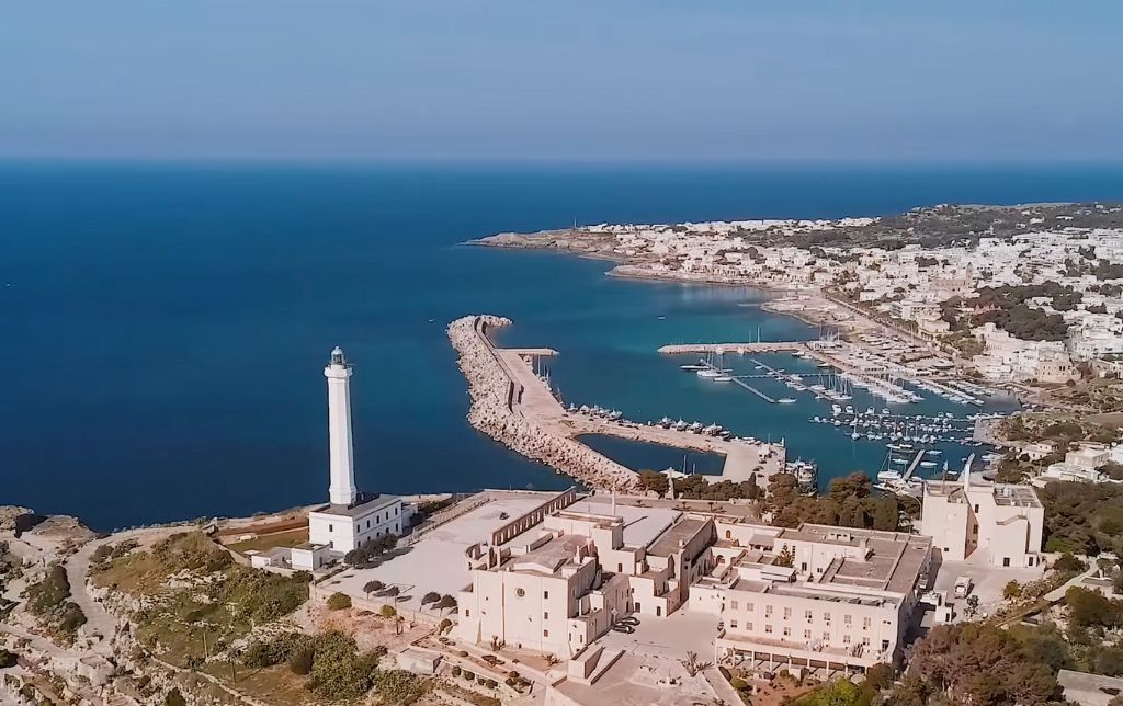 big gulf with boats, near a lighthouse and a big church - aerial view