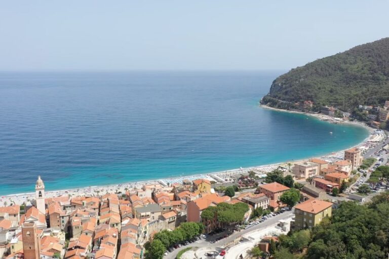 aerial viwe of shore village next to a very calm blue sea