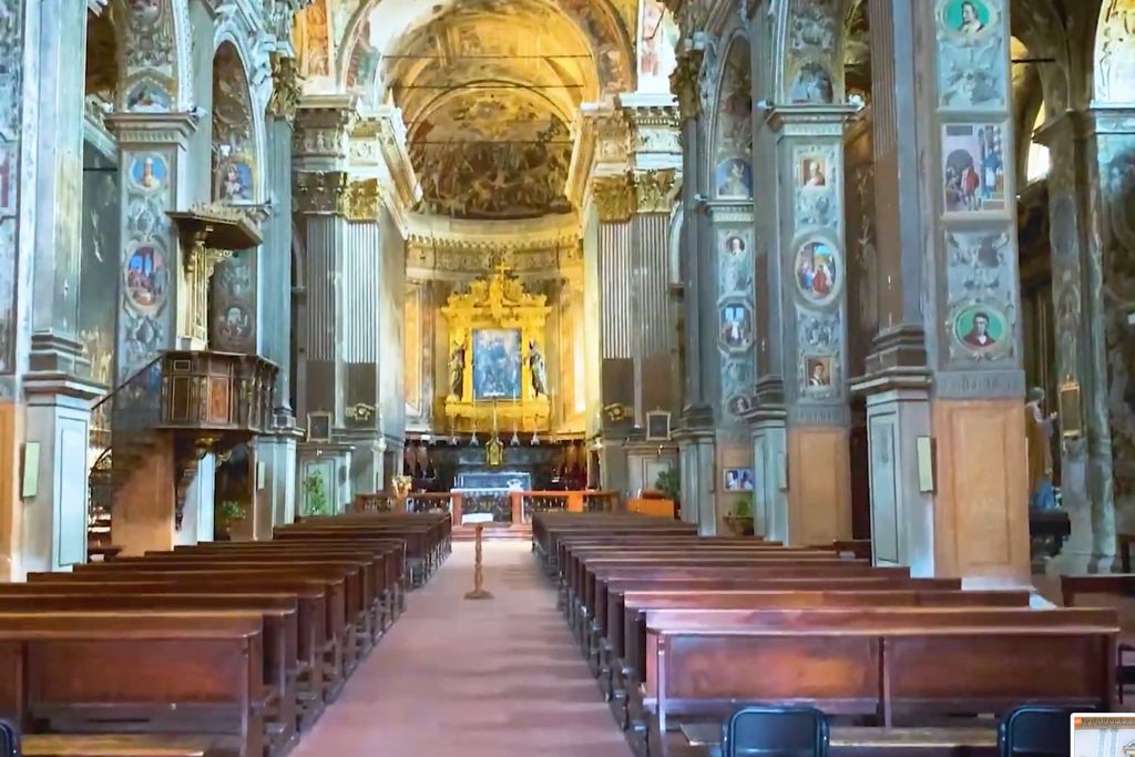 inside of a catholic church, wooden long chairs and golden balconies