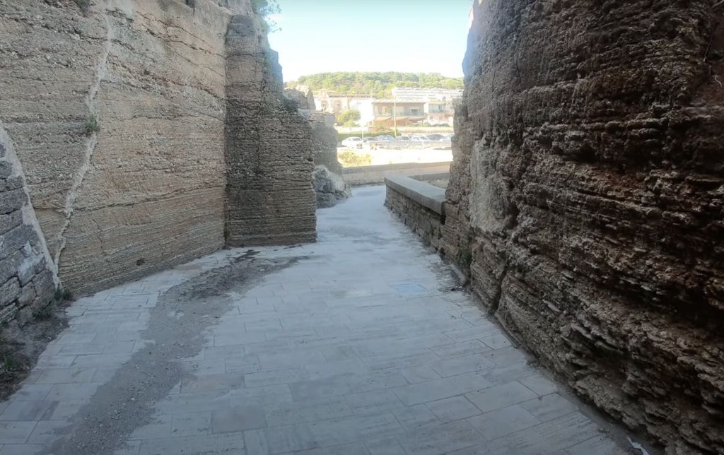 narrow stone walking path between ruin walls