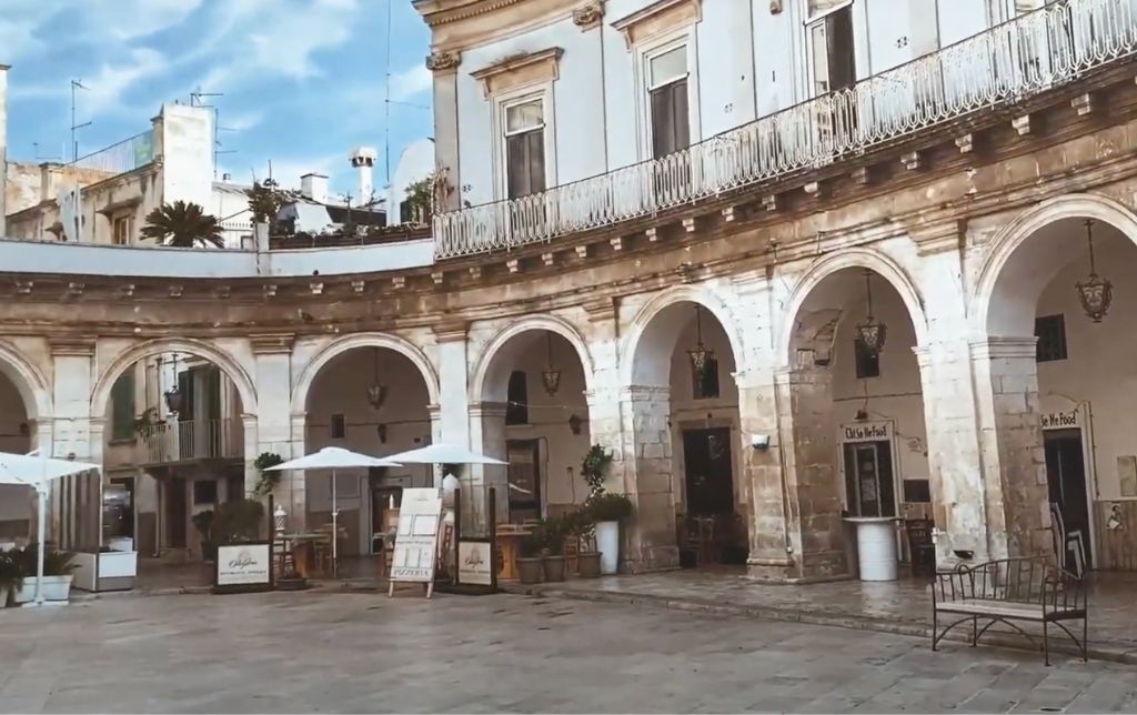 round town hall in a rainy day, iron bench and three white umbrellas in the rain