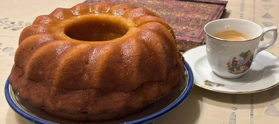lemonade cake bundt seating on a table near a coffee and a notebook