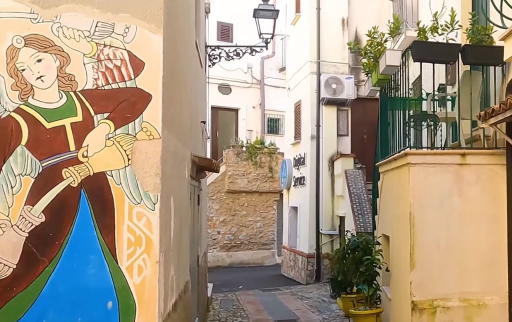 painted walls on yellow houses with balcon and plants