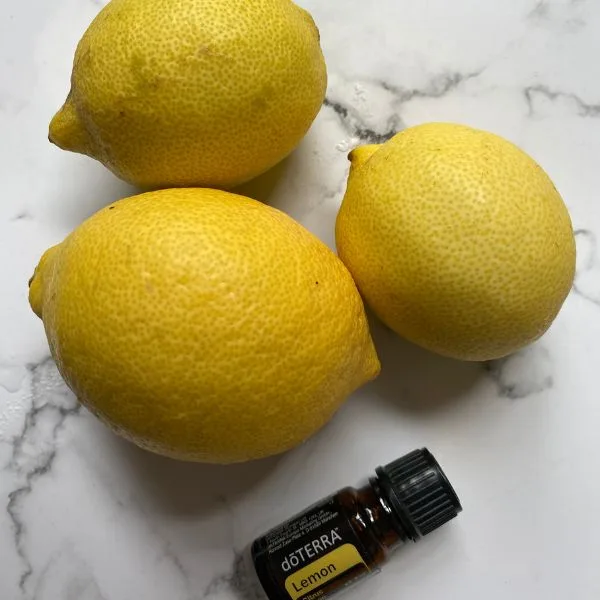 lemons and lemon essential oil seating on a marble table