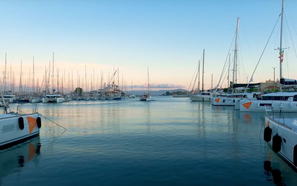 boats resting on a waveless blue water i the port