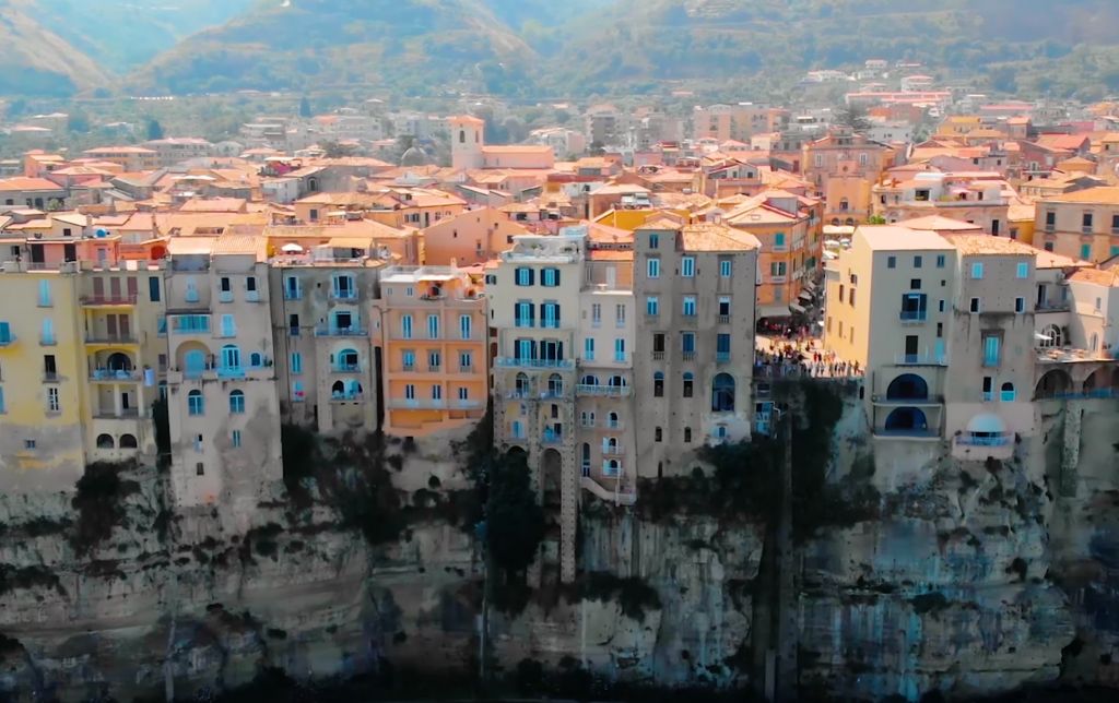 houses clinging on top of the rocks, directly above the dark sea