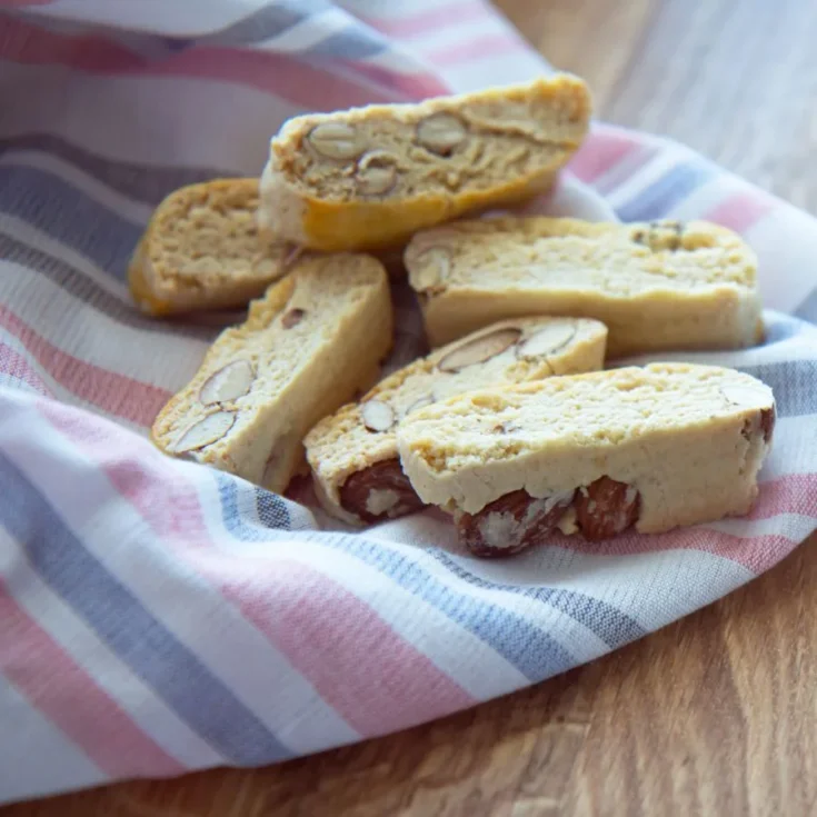 6 cantucci on a striped kitchen towel on a wooden table