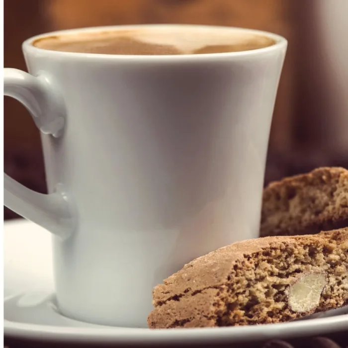 cup of coffee near cantucci on a white plate