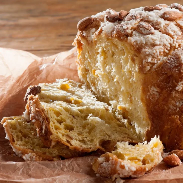 part of colomba pasquale, sliced in the left side, on a wooden table