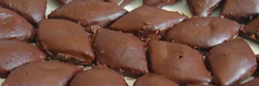 romboid chocolate glazed cookies sitting on a white plate