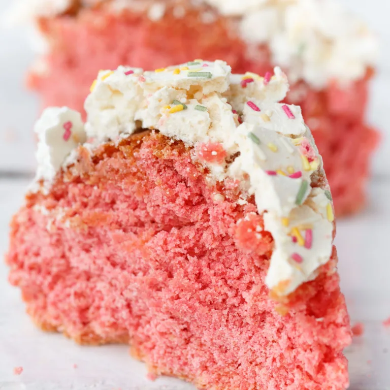 two slices of ciaramicola-red cake from italy-on a white marble table. the slices are glazed and sprinkled with colorful sweets