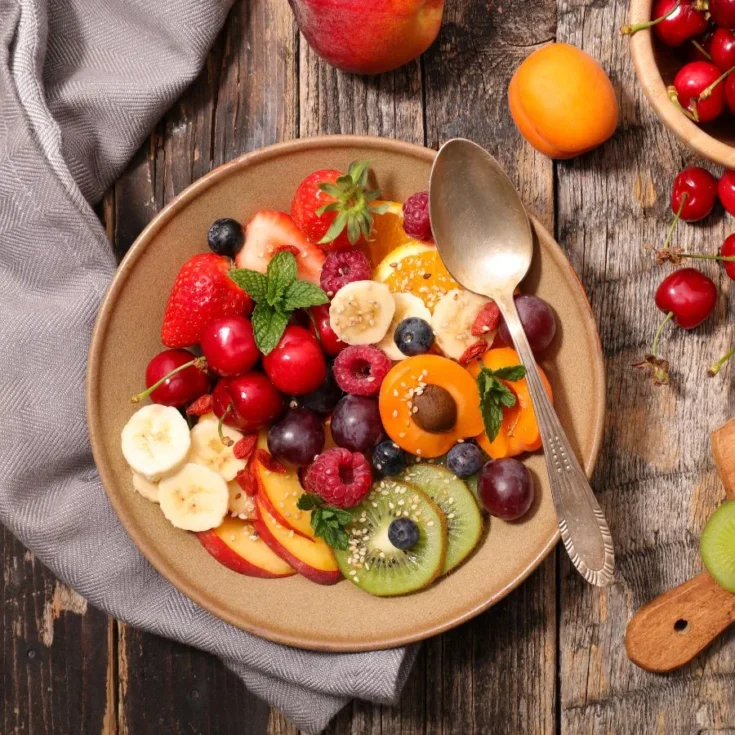 macedonia di frutta spring version on a beige plate on a wooden table