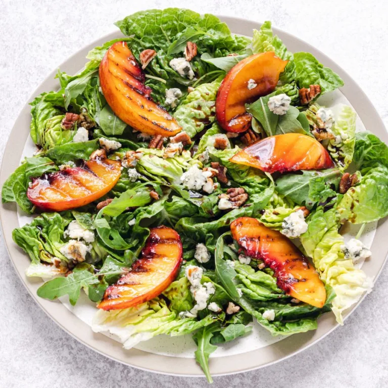 chicken peach salad in a white plate sitting on a white table