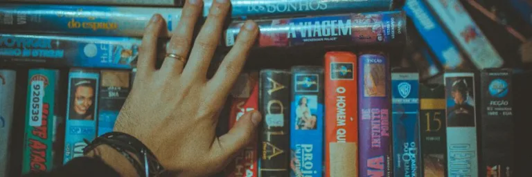 hand over a shelf full of video cassettes