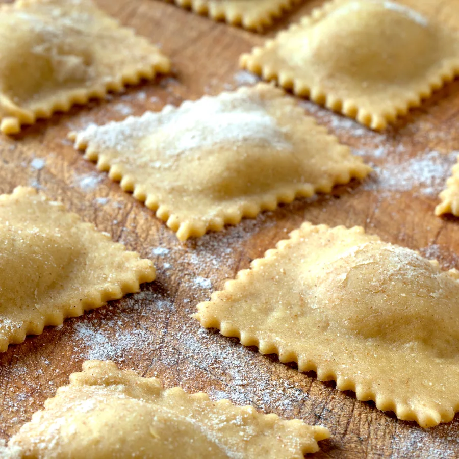 agnolotti cut into squares resting on a wooden table
